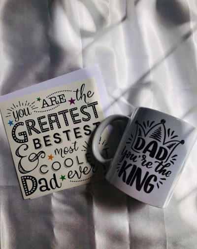 Father's Day Mug and Greeting Card combo featuring a customized mug with the message "Dad You Are The King" and a greeting card with the message "You Are The Greatest Bestest and Most Coolest Dad Ever" on a white background.