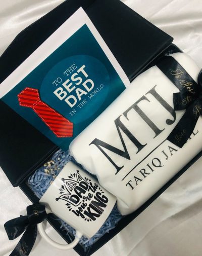 Father's Day Celebration Gift Box featuring MTJ Shalwar Suit Fabric, "Dad You Are The King" Mug, and Greeting Card, adorned with J's Store ribbons.