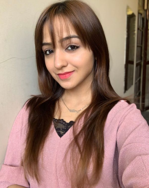 Influencer Muqaddas radiates joy as she showcases our Single Arabic Name Silver-Plated Necklace in a cheerful selfie, wearing a charming pink jacket with a black lace inner.