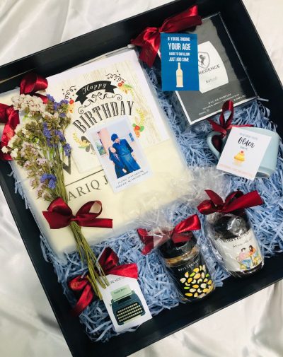 Brown Munde Gift Box with branded suits, flowers, birthday card, perfume, black marble cufflinks, mug, nuts jar, and coffee jar, beautifully decorated with mini cards and ribbons.