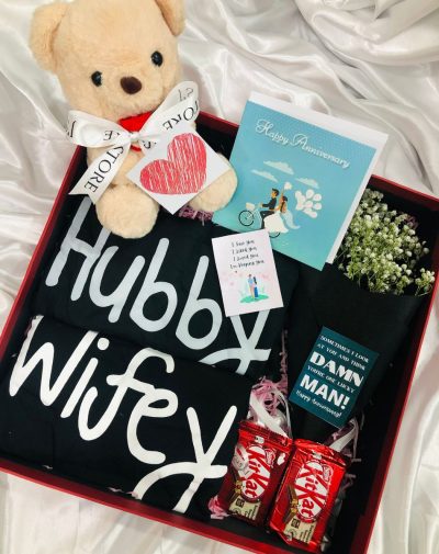 Soulmates Box For Anniversary contains couple T-shirts, a teddy, chocolates and a bouquet of fresh flowers.
