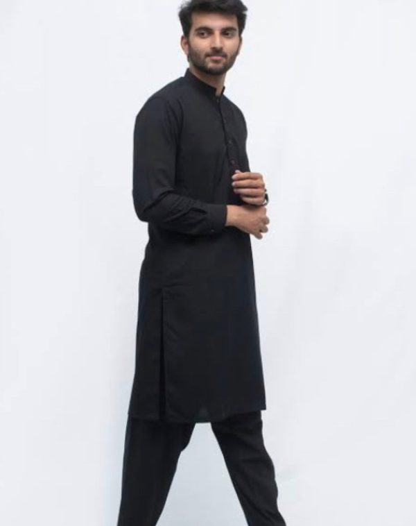 Stitched Kurta Pajama Plain Black - A young man wearing a plain black kurta pajama against a white background.