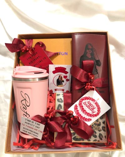 Luxe birthday gift box for women: personalized red wallet, cheetah print makeup bag, LV sunglasses, pink coffee mug. All beautifully wrapped with ribbons and cards.