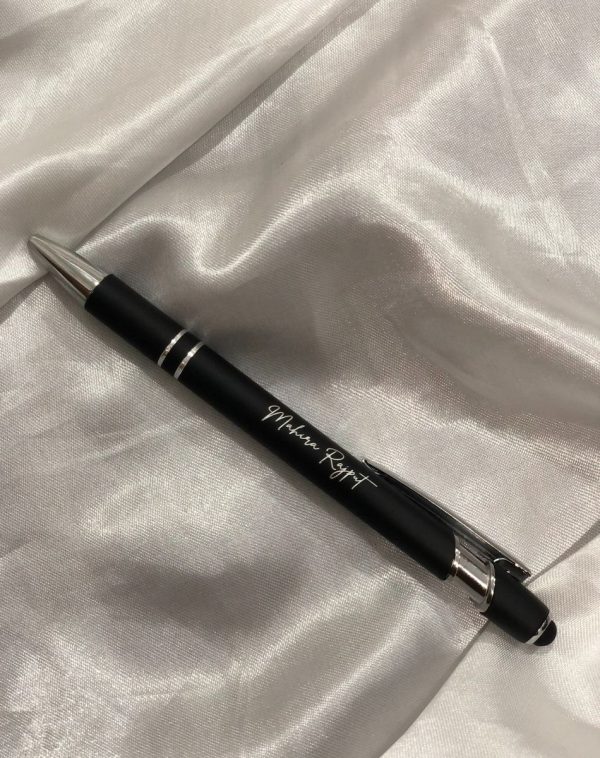 A close-up shot of the engraved metal pen with a name, highlighting the personalization aspect.