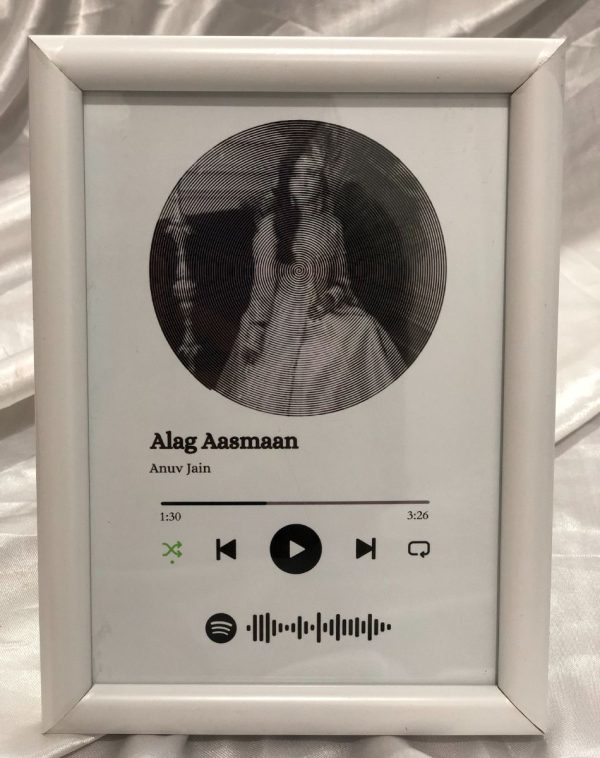 A picture of the customized Spotify frame playing a song, displaying the spiral betty artwork, customize song barcode and spotify music player. The frame is of White Color.