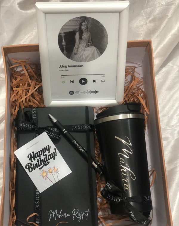 Exquisitely wrapped in a beige gift box, the Personalized Power Up Box for Her reveals a curated collection of personalized gifts: a white Spotify frame playing a song, a black temperature-indicating coffee mug, a black leather notebook, and an engraved metal pen.