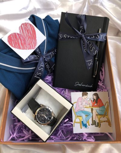 J's Store Executive Gentleman Gift Box featuring a crisp blue polo shirt, Tissot GMT watch, personalized leather notebook and name-engraved pen, elegantly arranged on a white silk background.