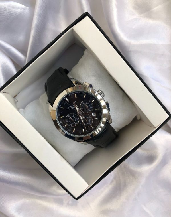J's Store TT-GMT Model watch, a blend of sleek black and shimmering silver, resting in its brand box on a pristine white background.