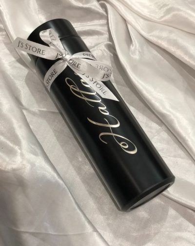 A name engraved customized temperature bottle in black colour with a decorative ribbon.