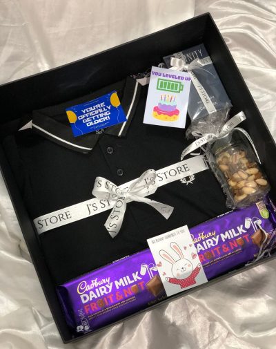 The Jackpot Gift box for him with Dairy Milk Fruits and Nuts chocolate, a jar of dried fruit, FP Black polo shirt with J's Store ribbon, and Eternity by CK cologne. Decorated with J's store ribbons, and special wishing cards.