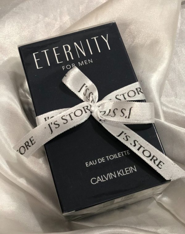 Bottle of Eternity men's cologne, included in a gift box for men. Decorated with J's store white ribbon and placed on satin white background.