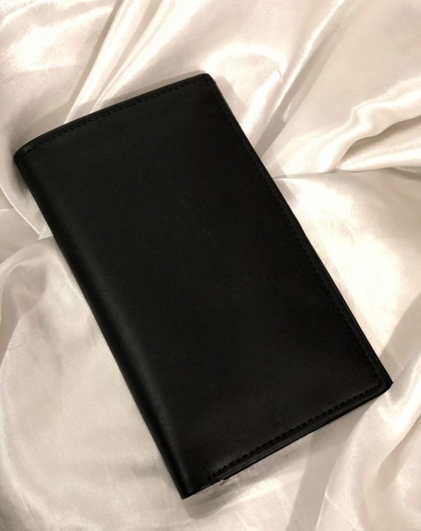 J's Store Black Long Leather Wallet for Men. A sleek, easy to carry wallet for men. It is placed on a white satin cloth.