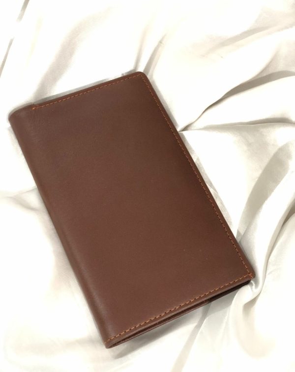 J's Store Dark Brown Long Leather Wallet for Men. A sleek, easy to carry wallet for men. It is placed on a white satin cloth.