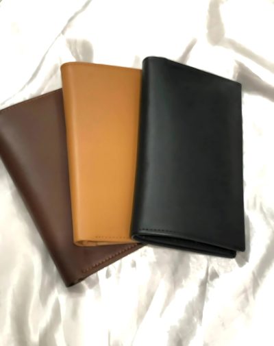 Long Leather Wallet for Men in brown, tan, and black colors displayed on white fabric background.