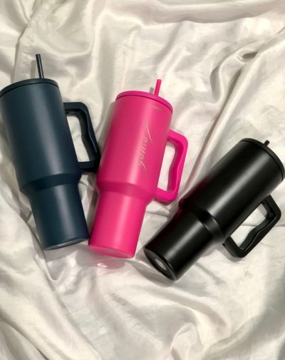 A set of three Quencher Tumblers in Black, Teal, and Shocking Pink, showcasing their sleek design and convenient handles.
