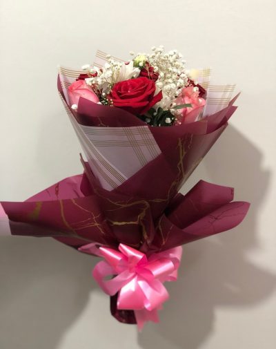 A Touch of Romance – A stunning bouquet of red and pink roses, white chrysanthemums, and baby’s breath, wrapped in elegant maroon and gold paper with a pink ribbon.