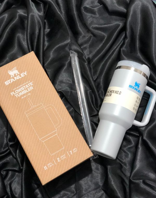 The Stanley The Quencher H2.0 Flowstate Tumbler in Ice Blue with its original packaging, showcasing the sleek design and durable construction.
