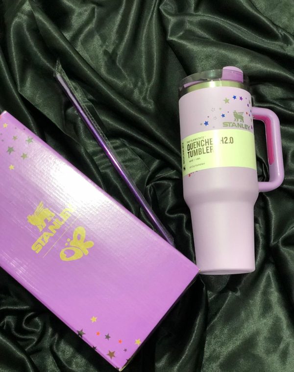 The Stanley The Quencher H2.0 Flowstate Tumbler in a special Limited Edition: Olivia Rodrigo design with a vibrant purple color scheme and star accents, shown with its original packaging.