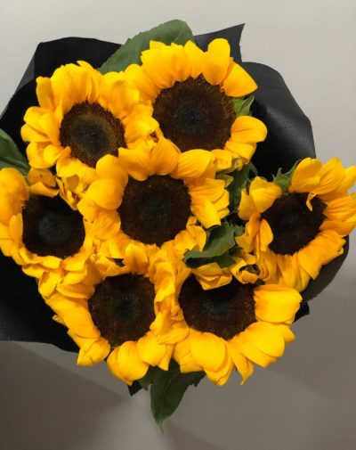 Sunflower Bouquet – A bright and cheerful arrangement of fresh sunflowers wrapped elegantly in black packaging.