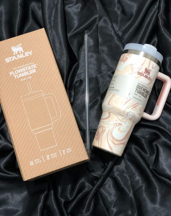 The Quencher H2.0 Flowstate Tumbler in a beautiful Coffee Swirls pattern with its original packaging, showcasing the sleek design and durable construction.