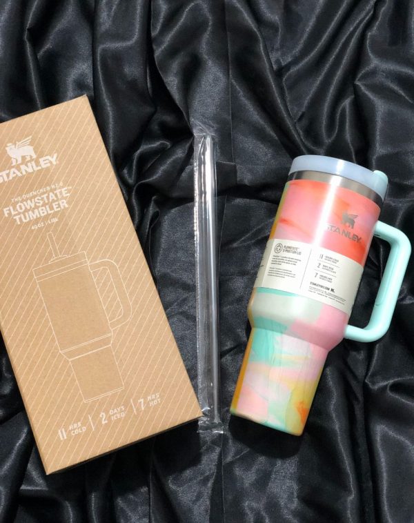 The Stanley The Quencher H2.0 Flowstate Tumbler in vibrant Cotton Candy with its original packaging, showcasing the unique design and durable construction.