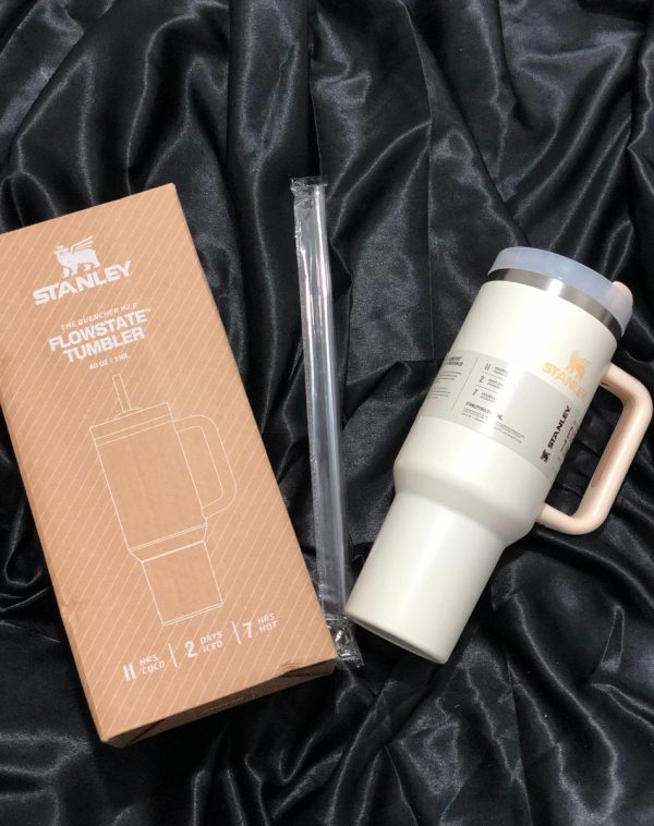 The Stanley The Quencher H2.0 Flowstate Tumbler in elegant Ivory with its original packaging, showcasing the sleek design and durable construction.