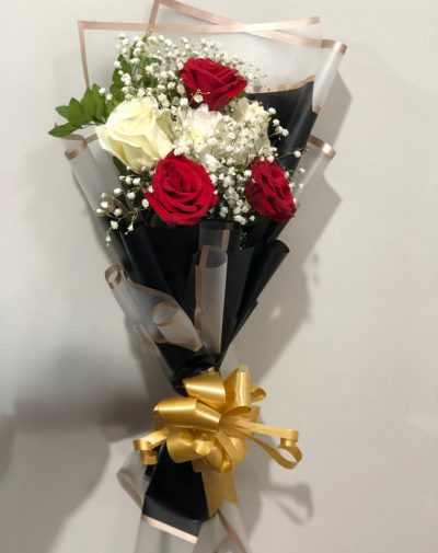 The Refined Bouquet – An elegant bouquet featuring red and white roses, white chrysanthemums, and baby’s breath, wrapped in luxurious black and gold paper with a golden ribbon.