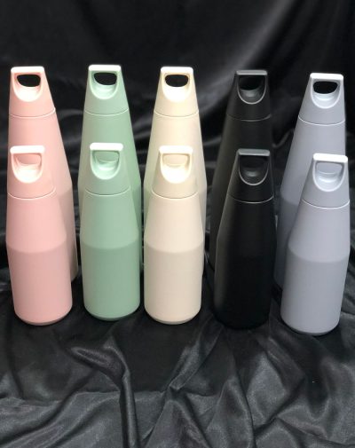 A collection of The Zen Flask in various colors, including baby pink, light green, vanilla, black, and gray, showcasing their sleek design and convenient handles in both 580ml and 1080ml sizes.