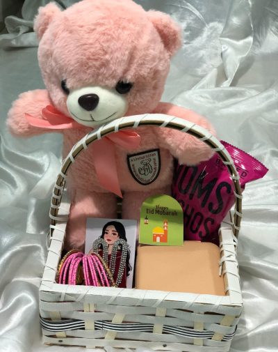 Eid Adornment Basket from J’s Store with a pink teddy bear, trendy bangles, dazzling earrings, jewelry organizer, and nachos.