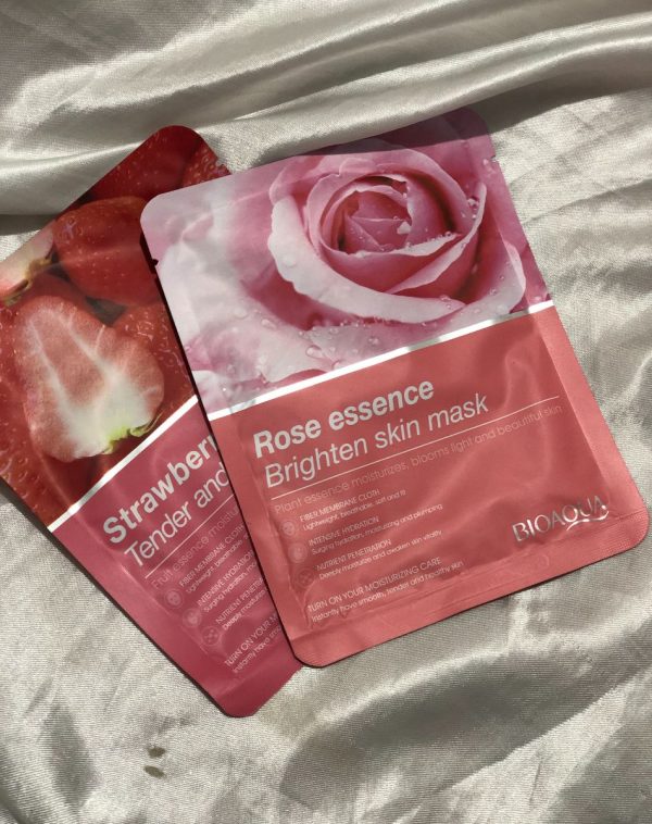 Two BioAqua sheet masks, one with a strawberry essence and the other with a rose essence for brightening.