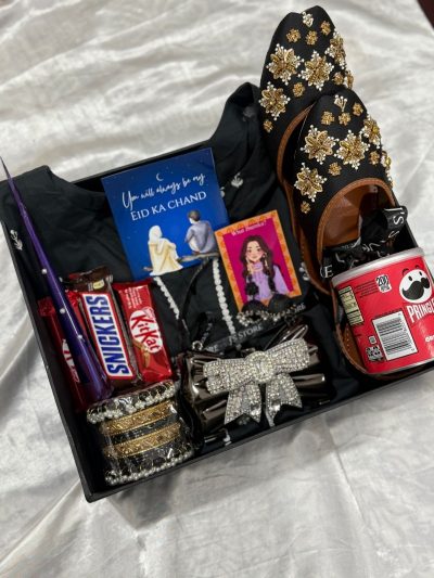 The Elegant Diva Hamper by J’s Store featuring a black suit, rhinestone clutch, and traditional accessories.