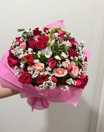 Crimson Blush Symphony bouquet featuring deep crimson red roses blush pink roses white gladiolus and baby breath in pink wrapping paper from J's Store