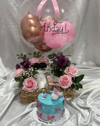 Enchanted Elegance Gift Assortment featuring jute basket pink roses coffee tumbler perfume nuts jar bobo balloon and blue cake from J's Store