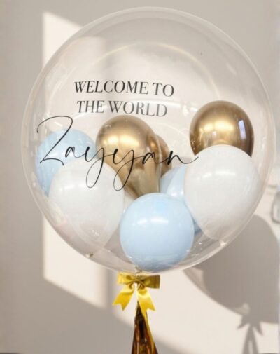 Personalized Bubble Balloon clear stuffed bobo balloon with metallic gold baby blue white mini balloons and custom welcome script from J's Store