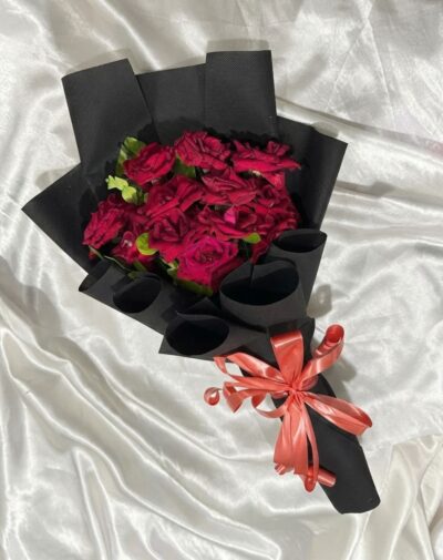 Shadowfall Red Roses featuring deep red roses wrapped in matte black paper with a coral ribbon bow from J's Store