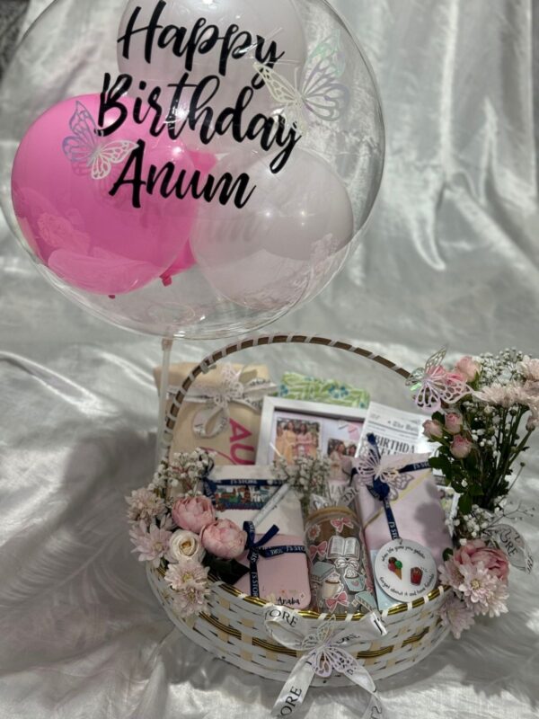 The Grand Wardrobe & Keepsake Basket View showing customized glass tumbler journal photo frame and floral arrangement in wooden basket from J's Store