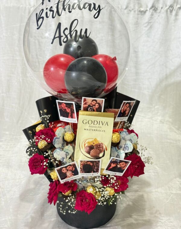he Royal Crimson Suite - Bouquet Bucket displaying red roses Godiva bar Ferrero Rocher cash origami and personalized balloon from J's Store